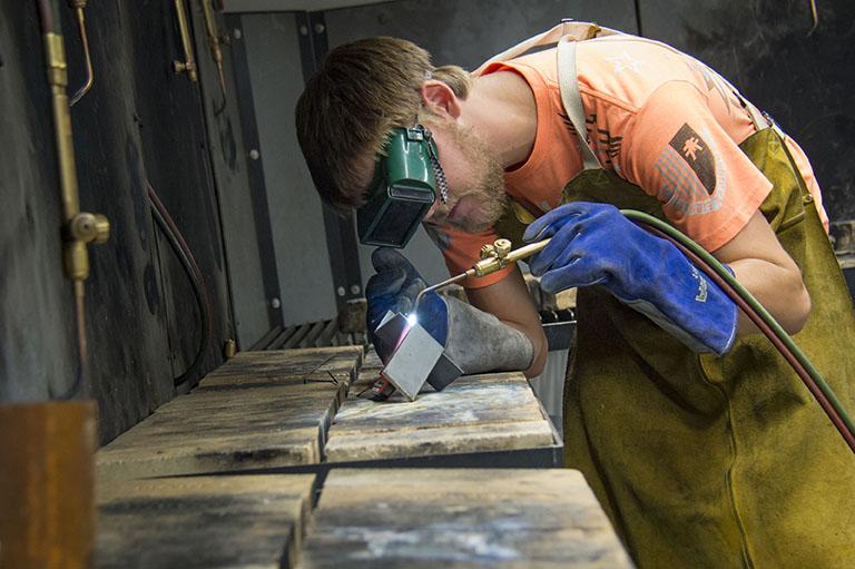 student using a welder